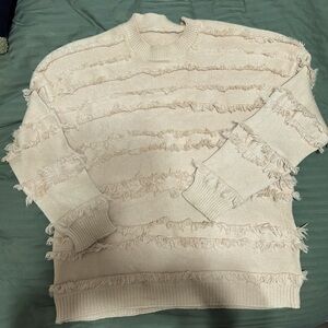 Apricot sweater with rows of fringe.